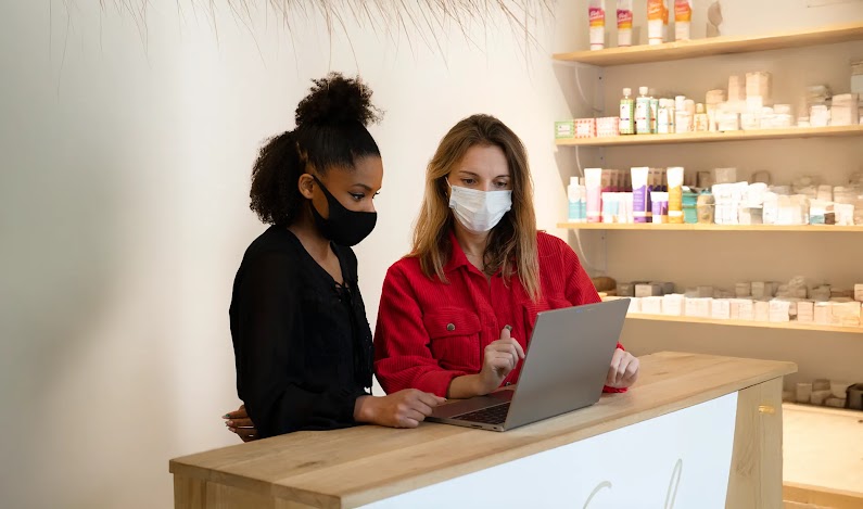 Deux femmes regardant un ordinateur dans un salon de coiffure