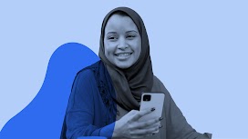 Uma mulher de minoria racial usando um hijab está sorrindo e segurando um smartphone.