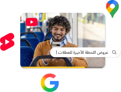 رجل بشعر مجعد يجلس في حافلة، يبتسم وهو ينظر إلى هاتفه الذكي. يظهر شريط بحث فوق الصورة يعرض نص "عروض عطلات اللحظة الأخيرة |". وتطفو حول الصورة المركزية أيقونات يوتيوب (YouTube)، ويوتيوب شورتس (YouTube Shorts)، وخرائط جوجل (Google Maps)، وشعار جوجل حرف "G".