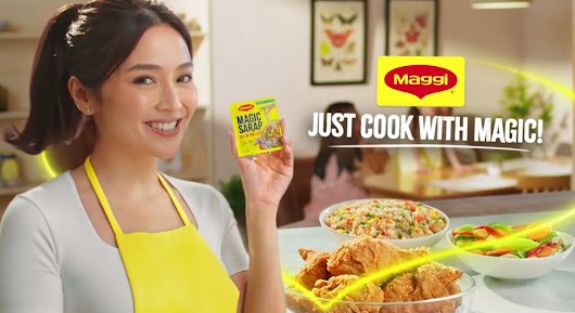 A Maggi advertisement featuring a smiling woman in a yellow apron holding a Maggi Magic Sarap packet, with the text 'JUST COOK WITH MAGIC!' next to a spread of food.
