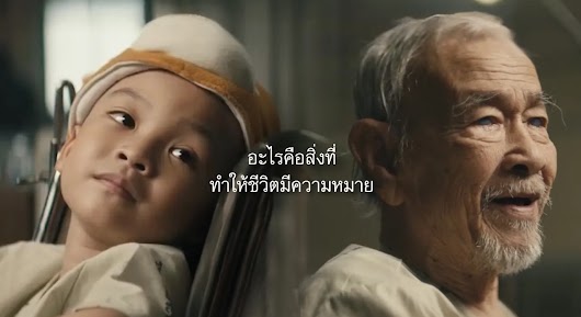 A cinematic video thumbnail showing a young boy with a head bandage next to an elderly man, with central Thai text asking what makes life meaningful.