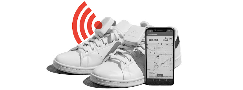 A mobile phone displaying a map placed beside a pair of shoes, representing Honda’s in-shoe navigation system which helps people with blindness or low vision