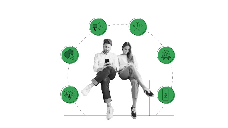 A black and white photo of a man and a woman sitting cross legged, using mobile phones. Around them, six icons. From left to right: a heart with three profile icons inside; a price tag and cursor; a megaphone; an arrow; a rosette; a mobile phone.