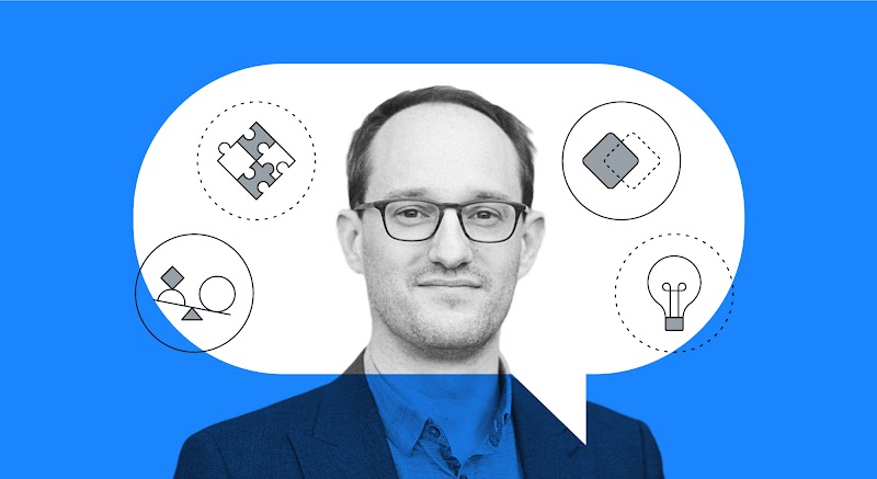 A imagem mostra a fotografia de David Mattin, autor do artigo. É um homem branco, calvo, usa óculos e tem cabelos claros. Ele usa um blazer por cima de uma camisa de botões.