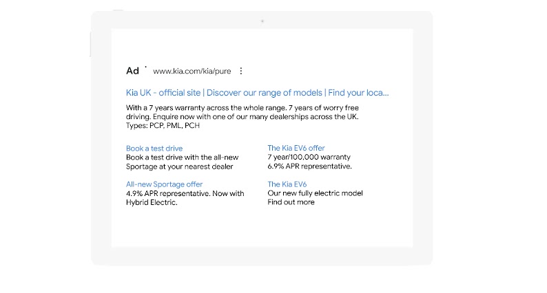 A search engine ad from kia.com. The title link reads: “Kia UK: official site, Discover our range of models”. The snippet focuses on the warranty offered for their whole range and includes a CTA. Below, four sitelinks with their own snippets.
