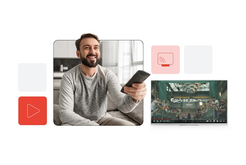A bearded man is sitting on a sofa with a remote control in his hand. He is smiling slightly. To the left, a play button inside a red box. To the right, in a paler red box, a TV and Wi-Fi icon. Below it, a Carlsberg ad is playing on a screen.