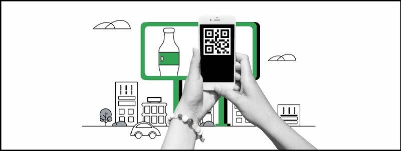 Unas manos en blanco y negro con un telefóno en la mano escanean un QR de un aviso de vía pública. Detrás un cartel en verde con una botella con etiqueta verde y el perfil de una ciudad.