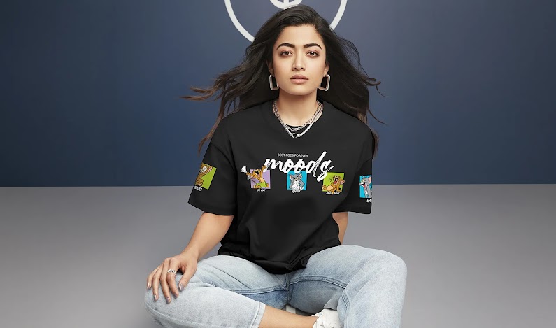 A woman wearing a black tee shirt and light blue denim sitting on the floor