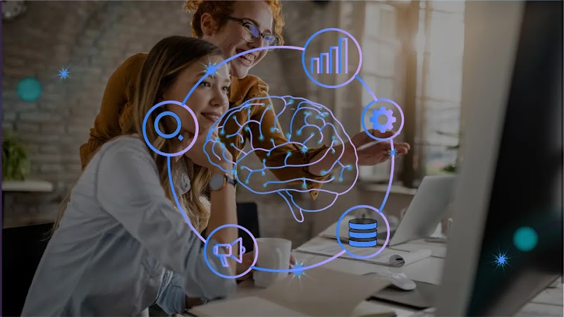 Dos mujeres sonríen frente a una computadora de trabajo. Sobre ellas, un dibujo de un cerebro en el centro y, a su alrededor, íconos de barras, un engranaje, una pila, una bocina y una lupa en tonos violetas y azules.