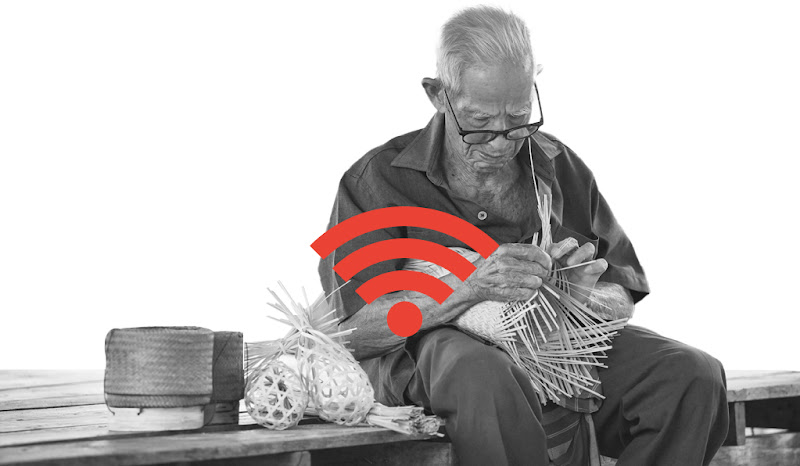 An elderly man weaving a rattan basket