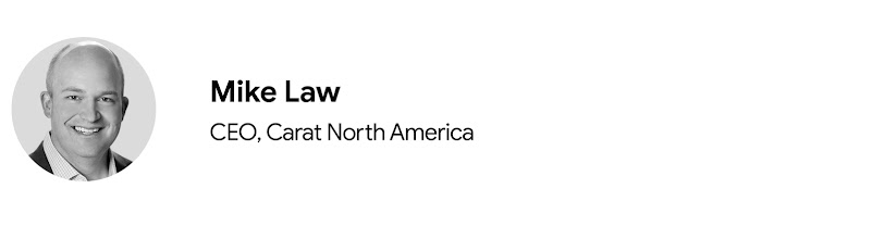 Foto del rostro de Mike Law, CEO de Carat para Norteamérica. Law es de piel clara y pelo muy corto, está sonriendo y lleva una americana y una camisa.