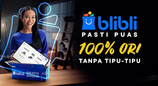 
The video thumbnail shows a woman dressed in a blue top, smiling widely while holding a tablet displaying various brand logos (Samsung, Adidas, JBL, Nike, L'Oréal, etc.). She is standing next to an open Blibli box in a dimly lit room. The right side of the image has large text on a black background that reads, "BLIBLI PASTI PUAS" (Blibli Definitely Satisfied) and "100% ORI TANPA TIPU-TIPU" (100% Original Without Scams), with the Blibli logo visible at the top.