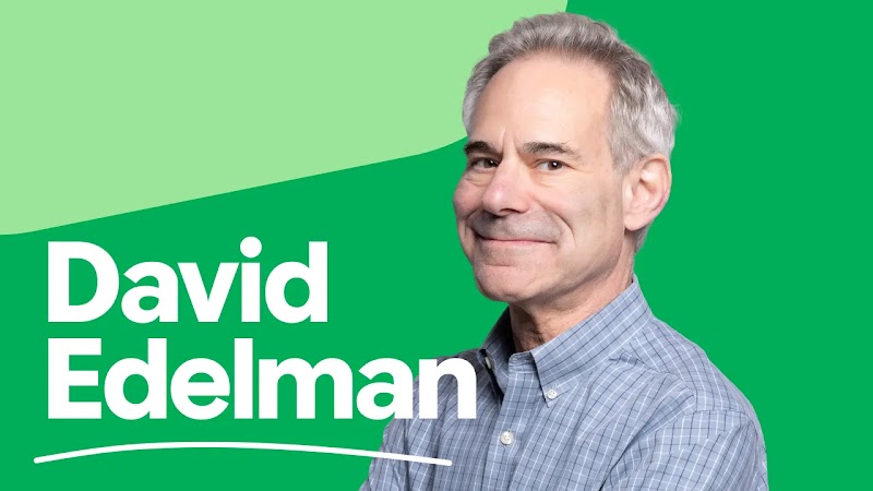 David Edelman, wearing a blue plaid shirt, smiles warmly in a portrait set against a vibrant green background. Large white text displays his name, underlined by a thin white arc.