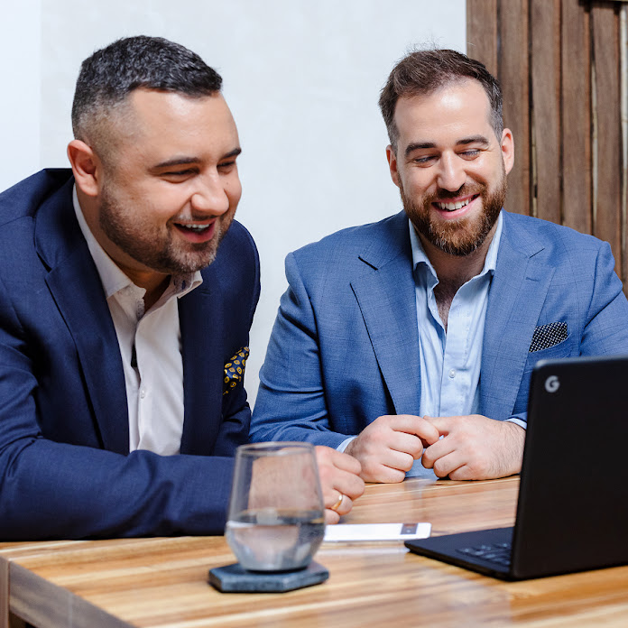 Two people are looking at a laptop and smiling. A button reading “15x return on ad spend” appears below them.