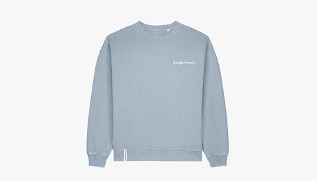 A unisex crewneck sweatshirt in Vintage Blue colour, featuring the "Google Partners" logo in white on the left chest and a small branded tag on the bottom hem.