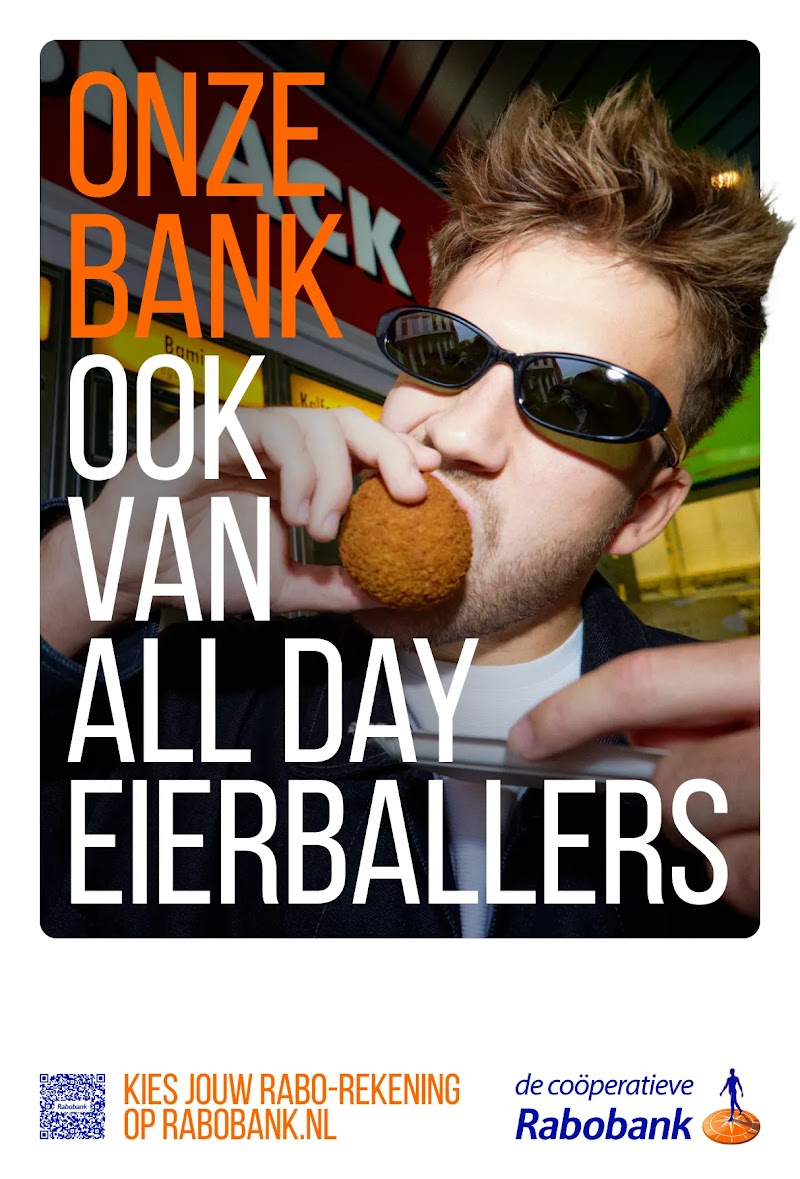 A man with sunglasses eats a fried snack in front of text reading "ONZE BANK OOK VAN ALL DAY EIERBALLERS". Below, "KIES JOUW RABO-REKENING OP RABOBANK.NL" appears alongside a QR code and the Rabobank logo. 