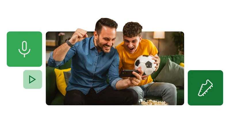 Homem de camisa azul e adolescente de camiseta mostarda assistem a uma partida de futebol pelo celular. O adolescente segura uma bola de futebol. Ao redor, ícones em verde de: microfone; play; e chuteira.