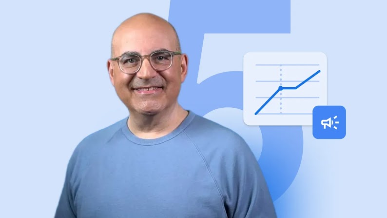 Shelly Palmer, CEO of The Palmer Group and Advanced Media Professor in Residence at Syracuse Univ. smiles at the camera, wearing a light blue pullover and glasses. He has light skin and a shaved head. A graph icon appears to his right.