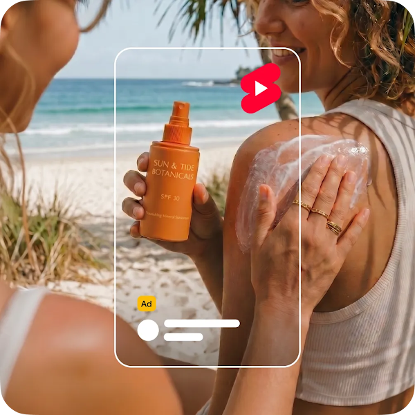 A woman applies sunscreen to a friend's shoulder at the beach, framed by a YouTube Shorts interface and a YouTube Shorts icon.