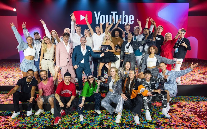Die Teilnehmer der Main Show des YouTube Festivals, wie Pamela Reif, Bodo Wartke, Rick Azas, Benjamin Henrichs, Alica Schmidt, Dani Verdari, Philipp Justus und Marianne Stroehmann, stehen für ein Gruppenfoto auf der Bühne zusammen.