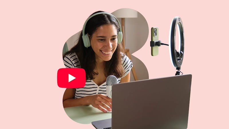 Against a pink background, a woman leans into a microphone, and smiles into a laptop video camera with a ring light next to it. The red YouTube play button logo floats nearby. 