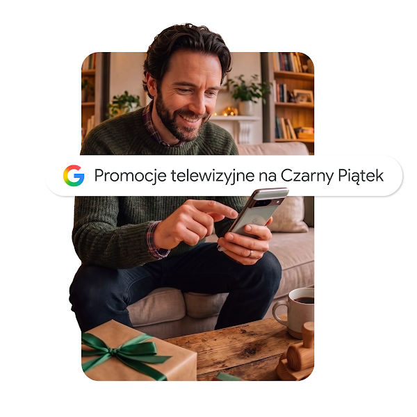 Grafika przedstawiająca uśmiechniętego mężczyznę siedzącego na kanapie, korzystającego ze smartfona z nakładką paska wyszukiwania Google o treści „Oferty telewizorów na Black Friday".