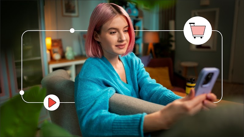 Una mujer con el pelo rosa está sentada en un sillón con un teléfono en su mano. Alrededor, una línea blanca con dos íconos: uno de YouTube y un carrito de compra en rojo.