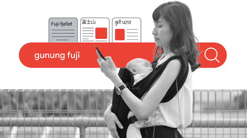 A young mother carrying her newborn and searching “gunung fuji” on her mobile phone with the help of Google translation