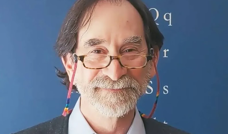 The owner of Laywine looks proudly into the camera in his stationery store.