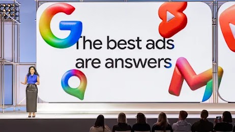 La ejecutiva de Google Vidhya Srinivasan habla a una audiencia desde el escenario de Google Marketing Live. Detrás de ella, una pantalla grande muestra una diapositiva de su presentación en la que se lee "The best ads are answers" (Los mejores anuncios son respuestas). Los logotipos de Google flotan alrededor de las palabras como si fueran globos.