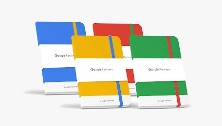  A set of four Google Partners notebooks in blue, yellow, red, and green, each featuring a contrasting elastic closure and a white "Google Partners" branded belly band.