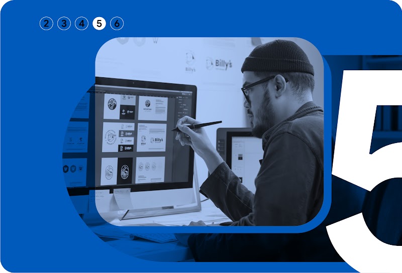 Capítulo 5 de 6. Un diseñador con barba con gorro de punto y gafas se sienta frente a un gran monitor mientras revisa ejecuciones creativas.