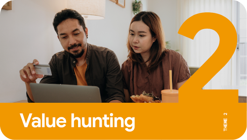 Theme 2: Value hunting. A couple sharing a laptop with the man holding up a credit card to make an online purchase.