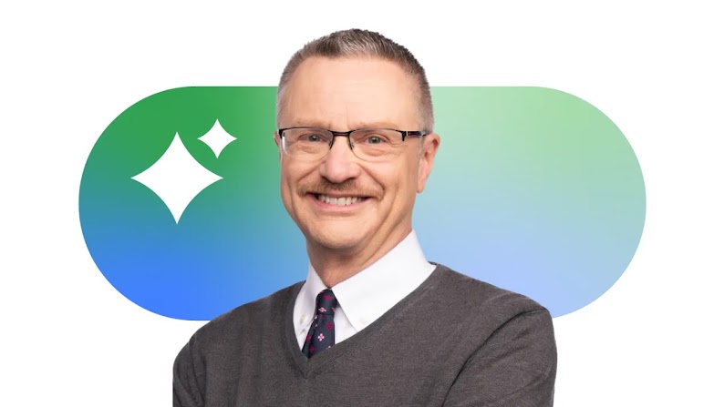 Professor and author Jim Lecinski is pictured, smiling. Lecinski has medium hair, light eyes and skin, and wears glasses and a sweater vest with a collared shirt and tie. Google’s AI sparkle logo appears behind him.