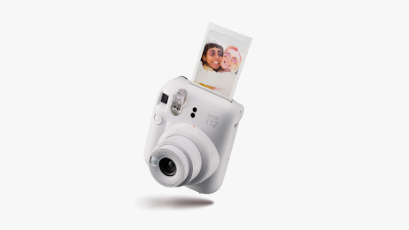 White Fujifilm Instax Mini 12 with a photo popping out.