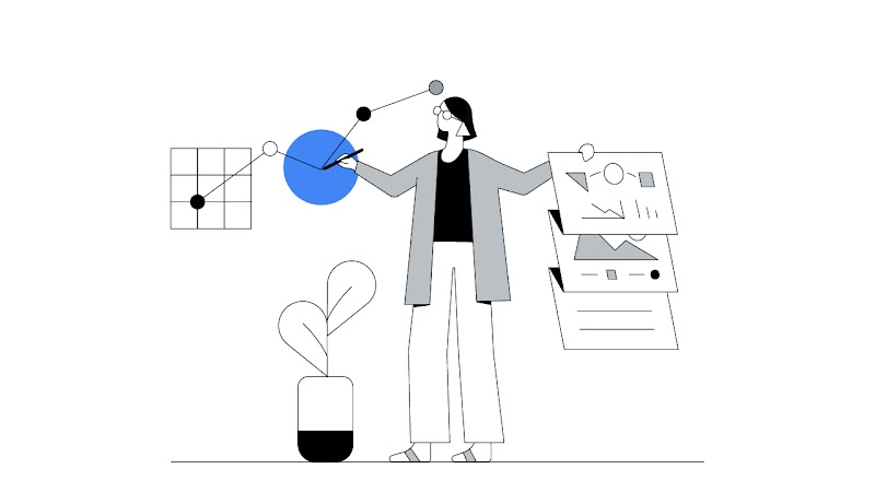 Uma mulher aponta uma caneta para um círculo azul e gráfico em ascensão e com a outra mão segura um painel sanfonado com elementos gráficos. Ela tem cabelo curto escuro e usa calças brancas, blusa preta e cardigan cinza.