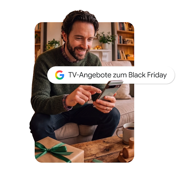 Eine Grafik zeigt einen lächelnden Mann, der auf einem Sofa sitzt und ein Smartphone mit einer Google-Suchleiste in der Hand hält. In der Suchleiste steht „TV-Angebote zum Black Friday".