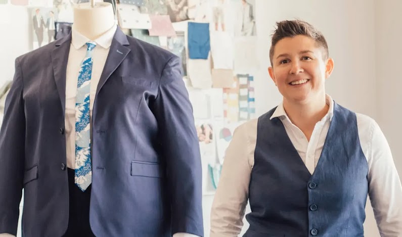 Co-Founder of Kirrin Finch standing next to a mannequin in a suit.