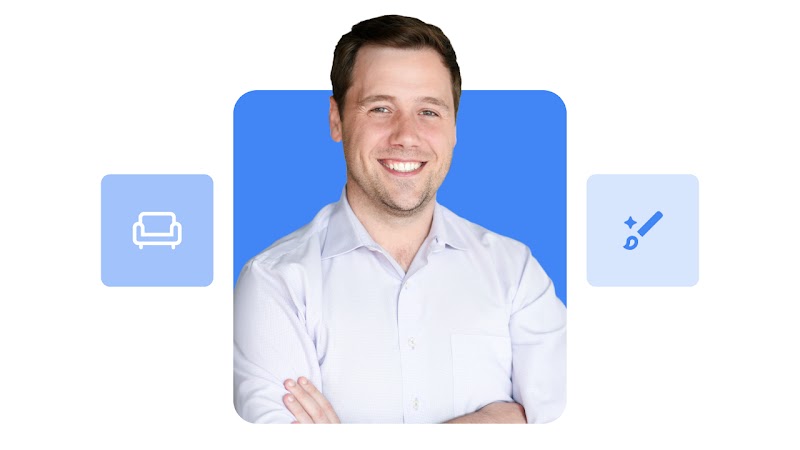 Wayfair CMO Paul Toms appears smiling before a blue background and between furniture and paintbrush icons. Toms has short dark hair, light skin, and wears a white button-down shirt.