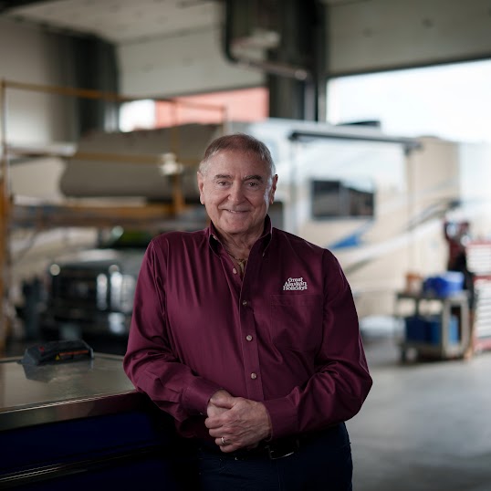 Owner of Great Alaskan Holidays Daryl Bennett standing in front of an RV from his fleet