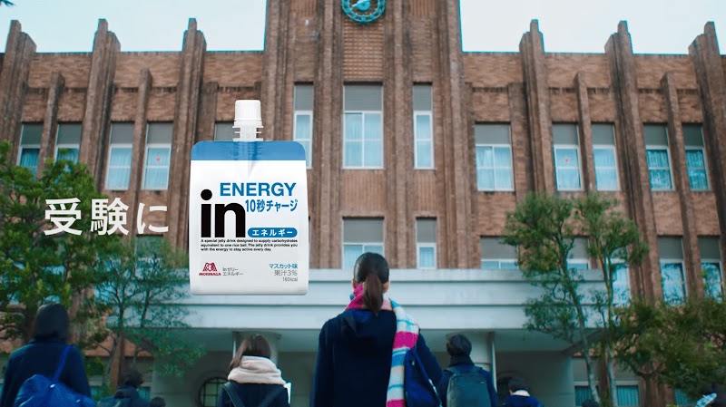 校舎、「受験に」in ゼリー。マフラーを巻いた女子生徒の後ろ姿。