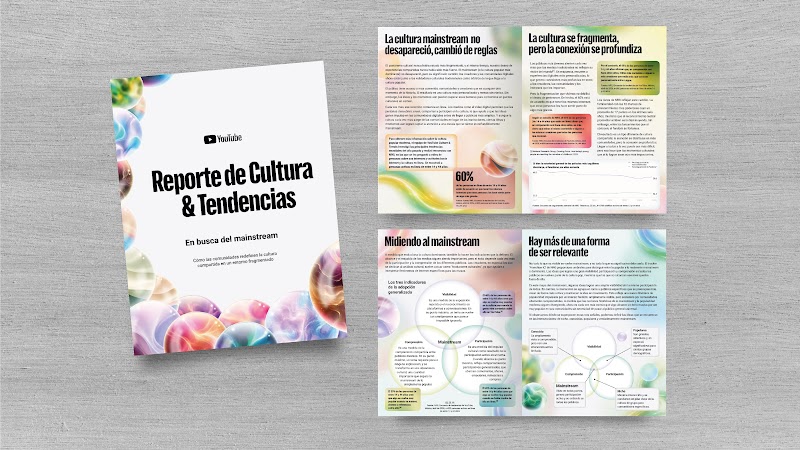 Un folleto impreso sobre madera clara muestra el «Reporte de Cultura & Tendencias. En busca del mainstream» de YouTube junto a sus páginas internas. Incluye secciones como «Midiendo al mainstream», «Hay más de una forma de ser relevante» y el dato 60%