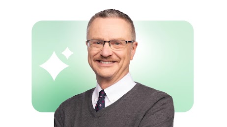 Professor and author Jim Lecinski is pictured, smiling. Lecinski has medium hair, light eyes and skin, and wears glasses and a sweater vest with a collared shirt and tie. Google’s AI sparkle logo appears behind him.