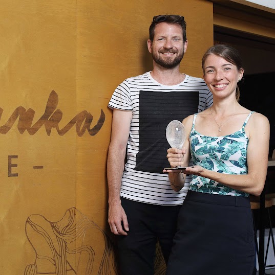 Zuzana Měřínská a Pavel Bechyně, majitelé kavárny Smetanka, stojí před stěnou s nápisem Kafe Smetanka a drží ocenění Křišťálový špendlík.