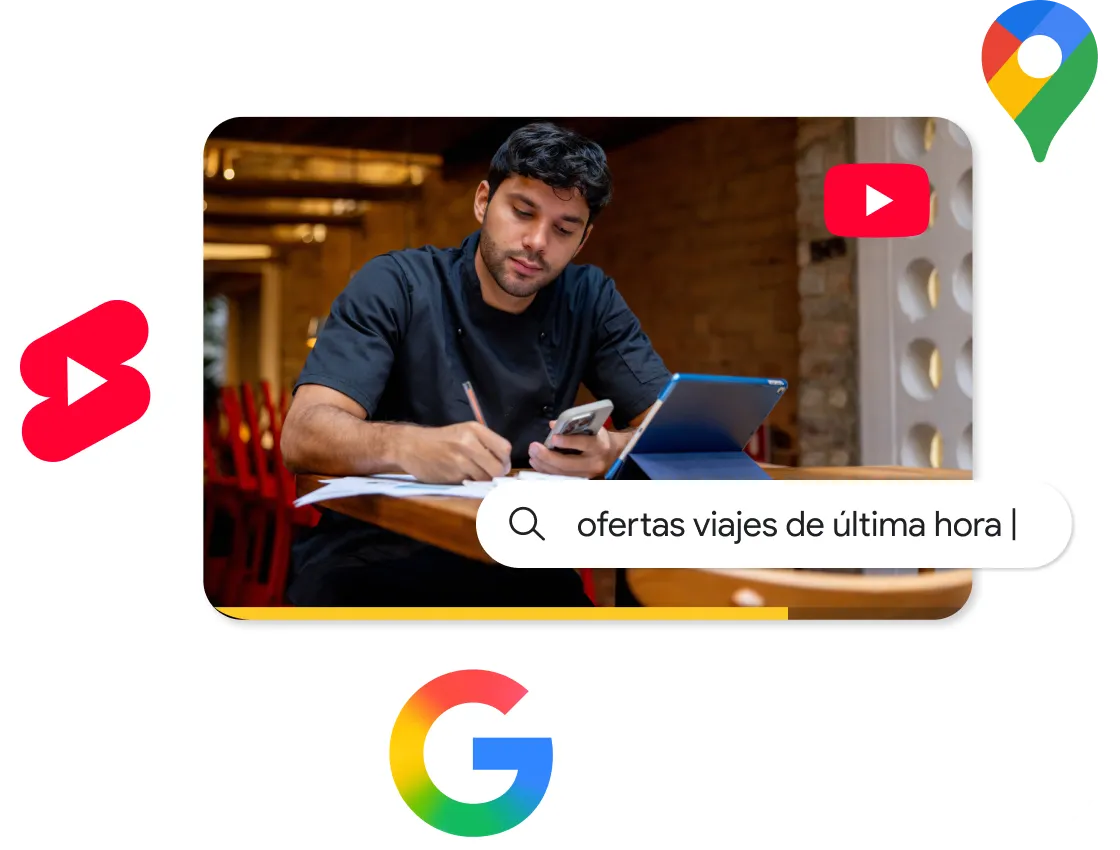  Imagen de un hombre sentado en una cafetería con su celular en la mano mientras escribe algo delante de una tableta. Elementos de la interfaz superpuestos con una barra de texto que dice “ofertas viajes de última hora” y los iconos de Google, YouTube y Shorts que sugieren la búsqueda de viajes y el descubrimiento de contenido en video.