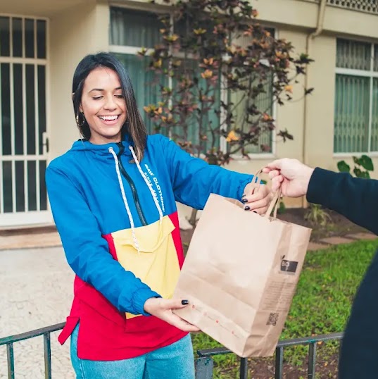 Un uomo sorridente con in mano una bottiglia di vino rosso
