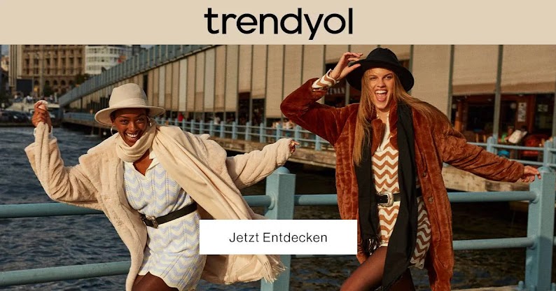 Dos mujeres posan sonrientes con ropa de Trendyol. Se puede leer el texto superpuesto "Trendyol. Jetzt Entdecken" (que significa "Descúbrelo ya").