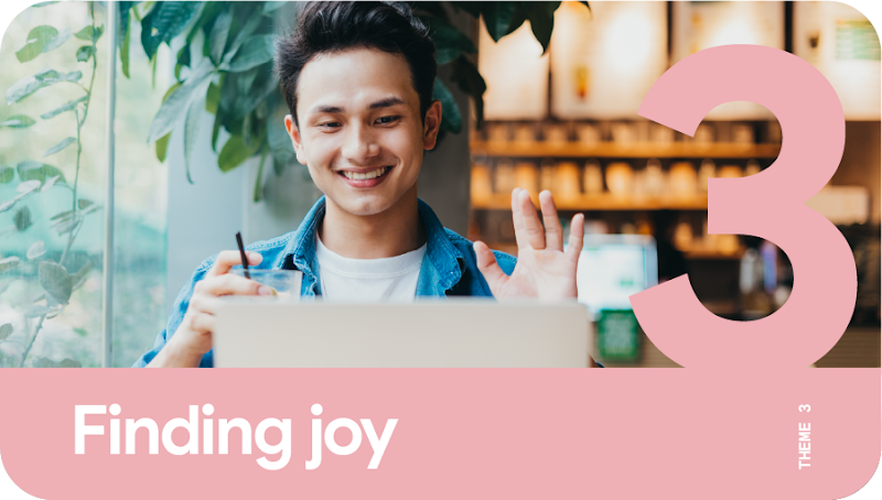 Theme 3: Finding joy. A young man waving at his laptop during a video call as he works remotely.