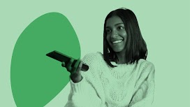 位穿吊帶褲和 T 恤的女性，面帶微笑坐在沙發上、拿著電視遙控器指向前方。