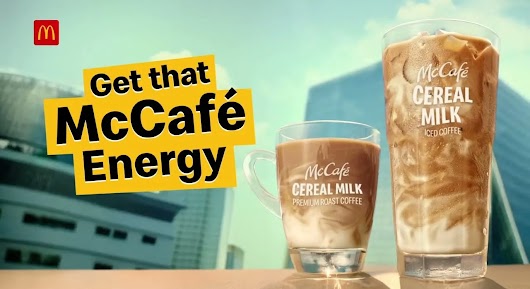 A McDonald's advertisement featuring two glasses of McCafé Cereal Milk Iced Coffee next to text reading 'Get that McCafé Energy'